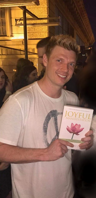 Nick Carter of The Back Street Boys holding Joyful Manifestation, the Book 